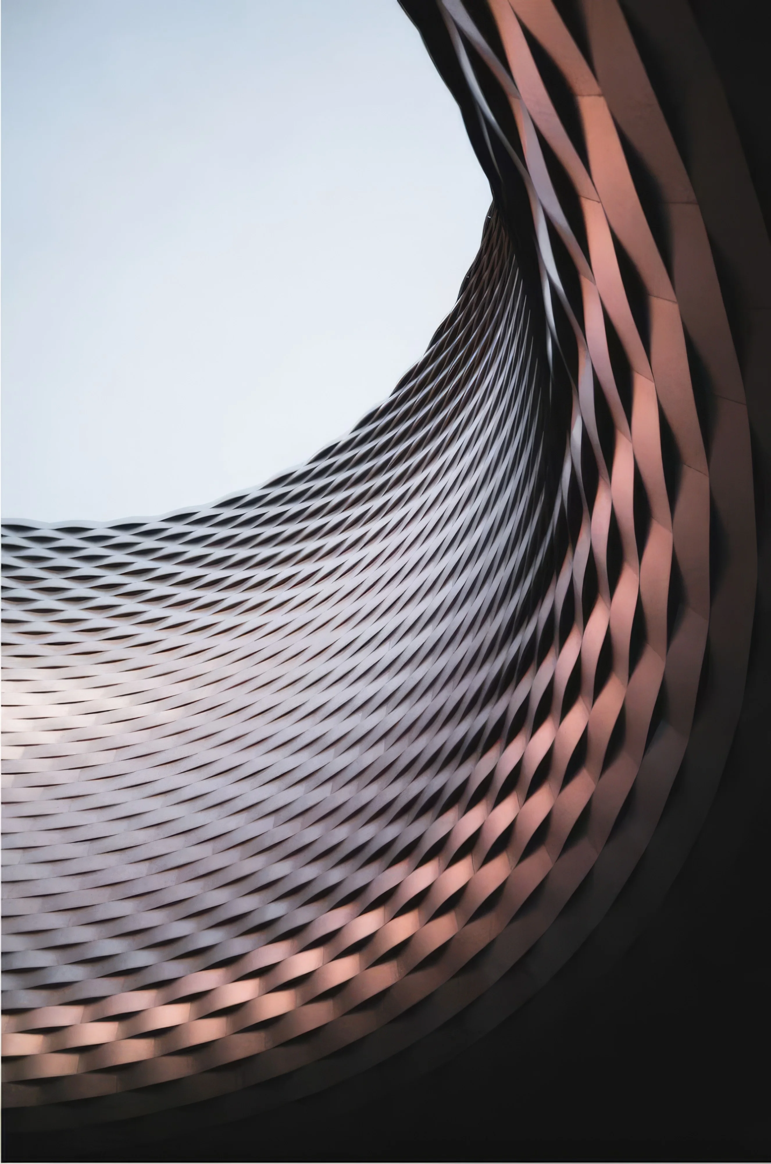 A curved metal facade in copper tones.
