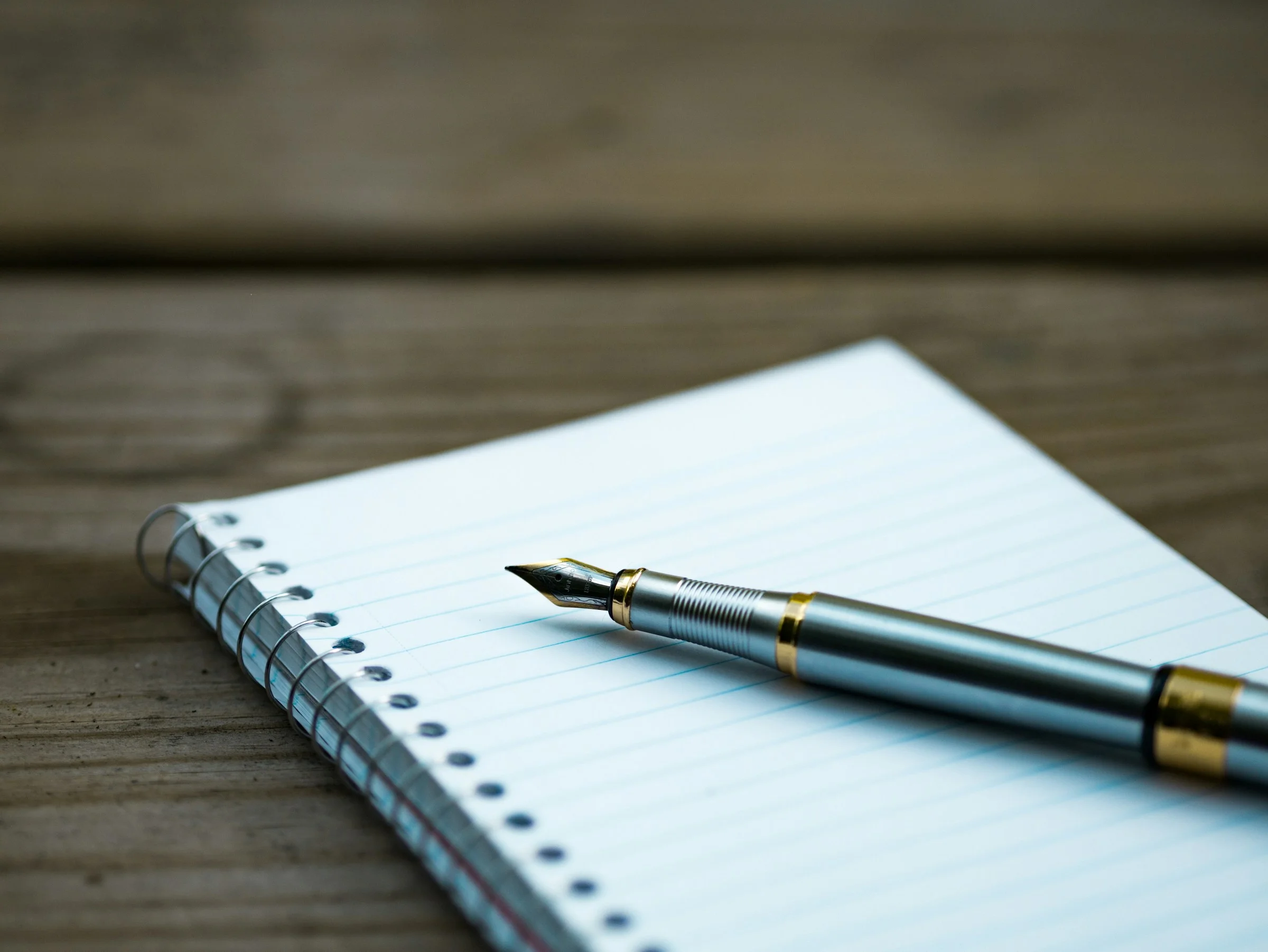 A fountain pen resting on an open notebook.